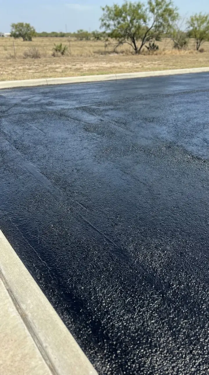 Freshly sealed asphalt pad with uniform black finish