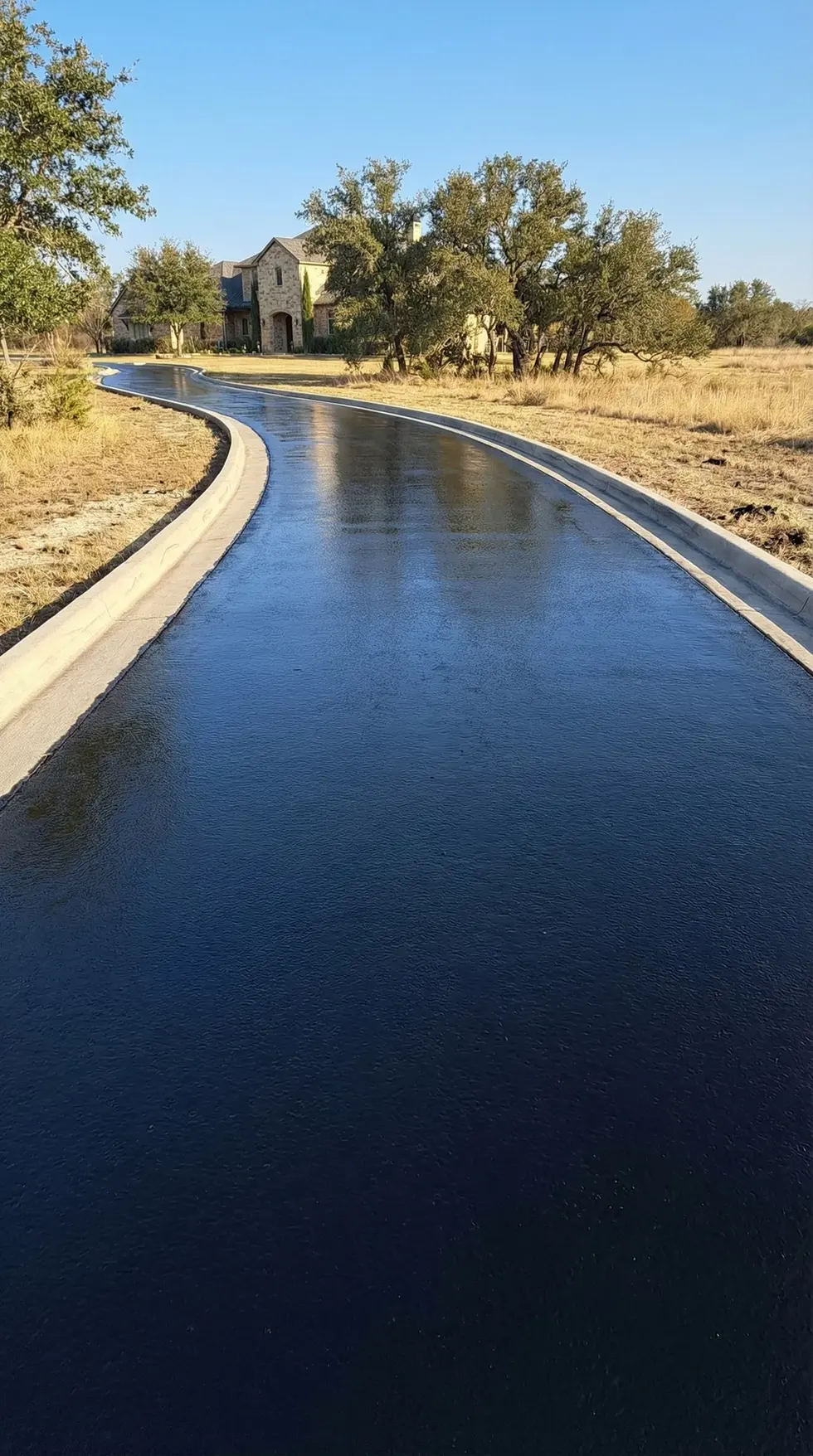 Freshly sealcoated driveway in Victoria, Texas with a mirror-gloss black finish